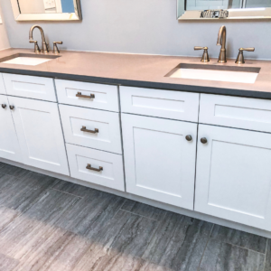 Bathroom dual-sink vanity featuring gray wood LVP, flooring